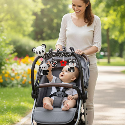 Une mère promenant son enfant en poussette avec une spirale d'activité par-dessus en forme de panda avec des motifs en noir et blanc
