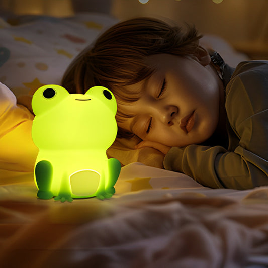 Enfant endormi en position ventrale, à côté de sa veilleuse bébé grenouille toute illuminé